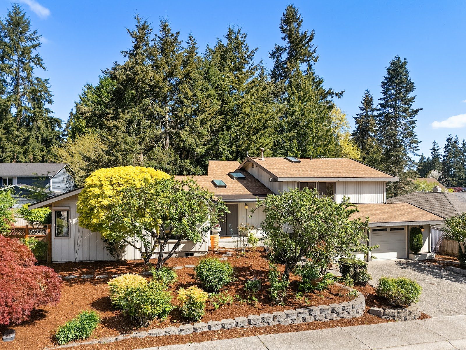 Finished shingle roof by Mass & Mass on a Redmond home among evergreen trees